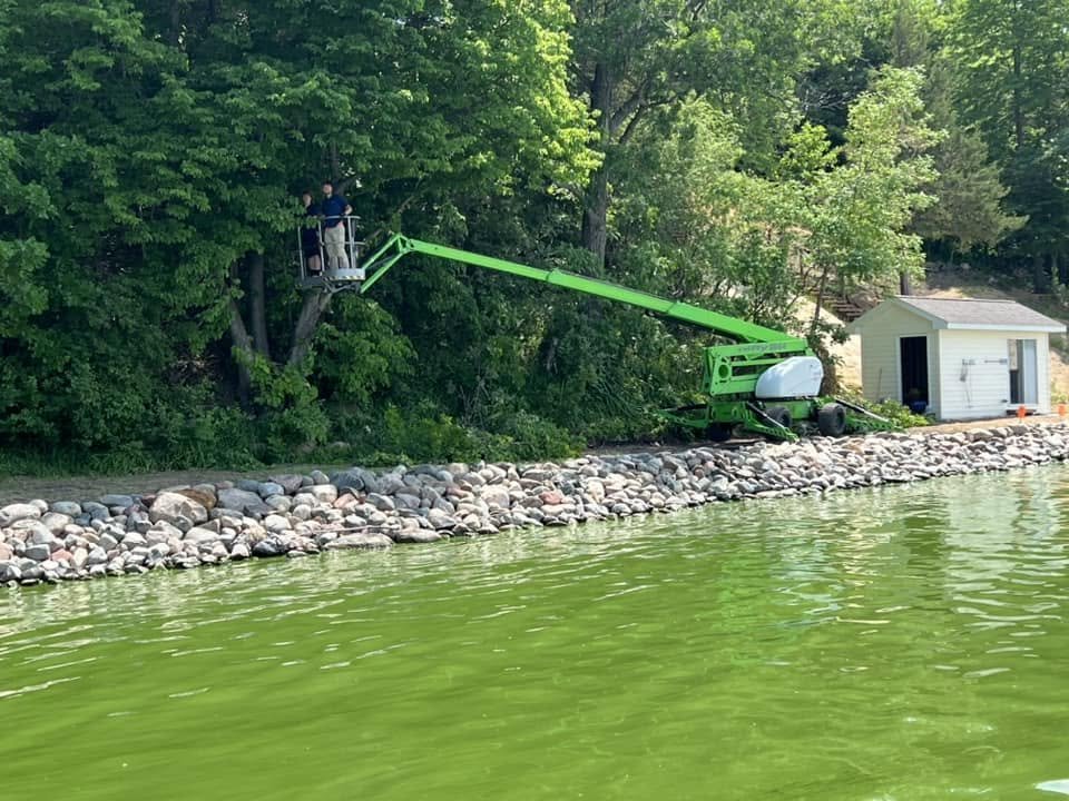 Tree trimming with boom lift near shoreline